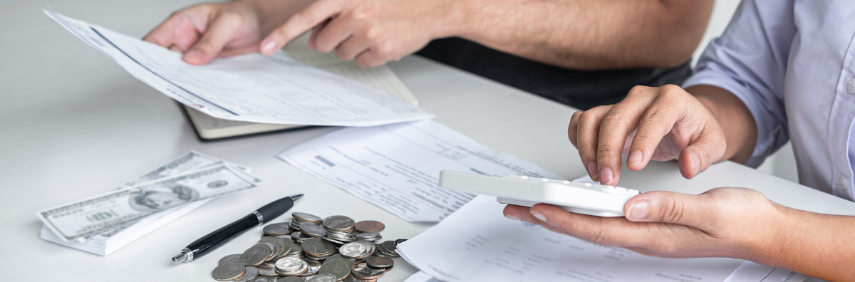 Hands holding papers and money on a table