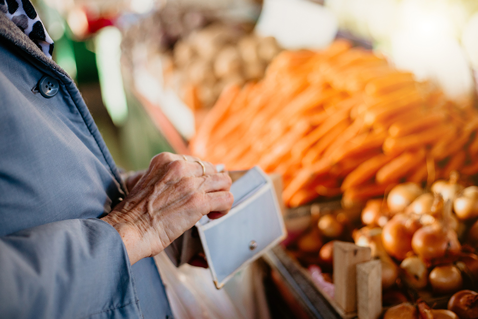 woman looking into her wallet at a grocery store