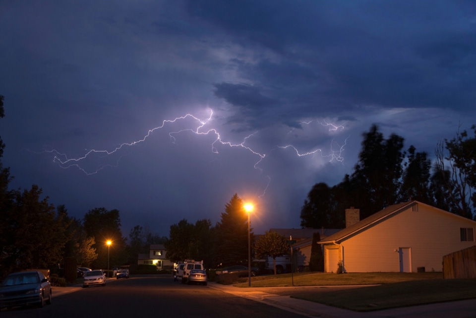 lightening in the sky over a residential neighborhood